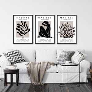 May include: Three black and white Matisse art prints with the title "MATISSE PAPIERS DECOUPES" and the artist's name and signature. The prints feature a stylized plant, a seated figure, and a cluster of leaves.