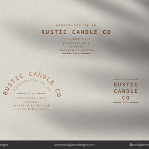 May include: A logo for Rustic Candle Co., a company that makes candles with essential oils. The logo is in a rustic style with a brown color scheme. The text "Rustic Candle Co." is in a large, bold font. The text "Handpoured in UK" is in a smaller font below the company name. The text "Est. 2021" is in a smaller font below the company name. The text "Essential Oils Candles Inspired by Nature" is in a smaller font below the company name.