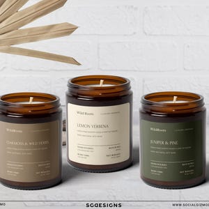 以下が含まれることがあります： 茶色の蓋とラベルが付いた3つのガラス瓶キャンドル。ラベルには「Oakmoss & Wild Herbs」、「Lemon Verbena」、および「Juniper & Pine」と書かれています。キャンドルは白い表面にあり、白いレンガの背景があります。ブランド名は「Wild Roots」です。