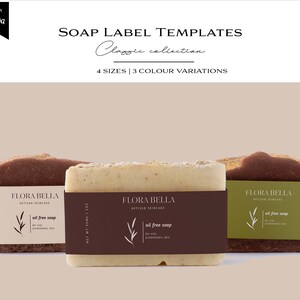 May include: Three soap bars with labels that say "Flora Bella Artisan Skincare" and "Oil Free Soap". The soap bars are brown, beige, and white. The labels are brown with white text and a green leaf design.