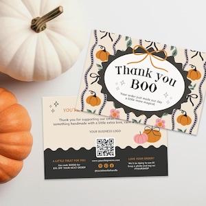May include: Two rectangular thank you cards with a cream background, orange pumpkin illustrations, and black scalloped borders. The top card features the text Thank you BOO and a bow. The bottom card includes a QR code, business text, and social media icons.