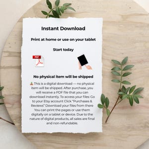 May include: A white paper with the words "Instant Download" and other text, along with a PDF icon and a tablet icon. The paper is on a light-coloured wooden surface, with green leaves in the background.