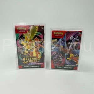 May include: Two Pokemon trading card game booster bundles in clear protective cases. One bundle is labeled "Ascended Heroes" with colorful graphics. The other is labeled "Destined Rivals" with various characters.