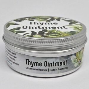 May include: A round silver metal tin containing Thyme Ointment. The lid features a white label with green thyme leaves and the text Thyme Ointment. The side label displays the text Thyme Ointment, Concentrated Formula, Made in Puerto Rico.