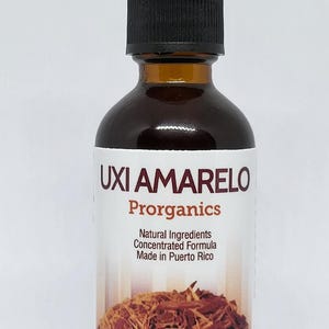 May include: A brown glass bottle with a black dropper top. The label reads "Uxi Amarillo Proorganics Natural Ingredients Concentrated Formula Made in Puerto Rico". The bottle contains a brown liquid and is filled with brown wood chips.