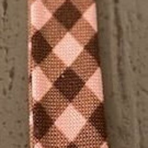 May include: A brown and pink gingham ribbon with a diagonal pattern.