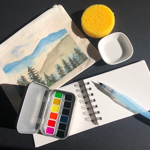 Kit de viaje para acuarela, cuaderno mediano de algodón 100 % prensado en frío, bolsa de lona, paleta compacta, pincel de agua Pentel de 4 tamaños, plato de cerámica para mezclar.