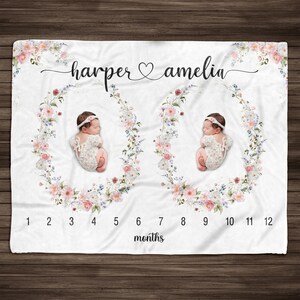 May include: A white baby blanket with a floral wreath design and two baby photos. The blanket has a number scale from 1 to 12 months and the text "harper & amelia" at the top.