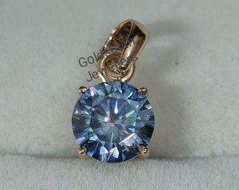 May include: A gold pendant with a large, round, blue gemstone. The gemstone has a faceted cut and is set in a gold setting.