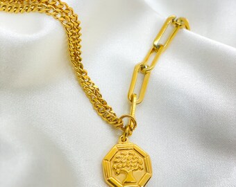 May include: A gold chain necklace with a gold pendant featuring a stylized tree design. The chain is a combination of a curb chain and a link chain.