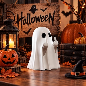 Peut inclure: Une figurine de fantôme blanc avec deux yeux noirs, levant ses deux majeurs. Le fantôme est placé devant un panneau en bois portant l'inscription Halloween, entouré de citrouilles, d'une lanterne noire avec une bougie et d'un petit chapeau de sorcière.