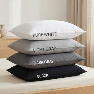 Pode incluir: Uma pilha de quatro almofadas em tons variados de cinza e branco. A almofada superior &eacute; branco puro, seguida de cinza claro, cinza escuro e preto. O nome da cor &eacute; impresso em cada almofada.
