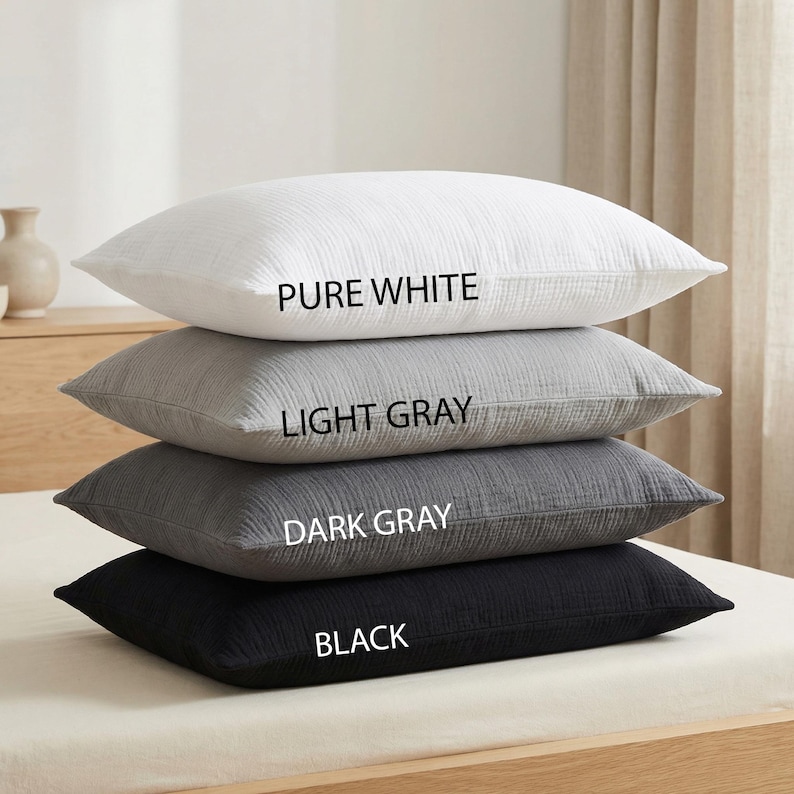 Pode incluir: Uma pilha de quatro almofadas em tons variados de cinza e branco. A almofada superior &eacute; branco puro, seguida de cinza claro, cinza escuro e preto. O nome da cor &eacute; impresso em cada almofada.