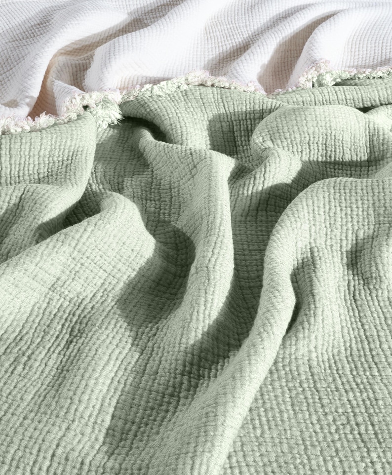 May include: A soft, green, textured throw blanket with a white fringe border.