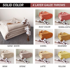 May include: Ten different colours of 4-layer gauze throws. The throws are folded and arranged in a grid pattern. Each throw is photographed on a white surface with a sprig of cotton.
