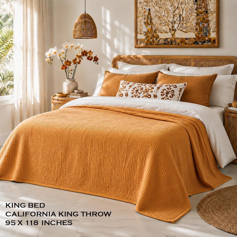 K&ouml;nnte beinhalten: Ein Kingsize-Bett mit einer California-King-Tagesdecke in den Ma&szlig;en 241 x 300 cm. Das Bett ist mit einer strukturierten, senfgelben Tagesdecke, passenden Kissenbez&uuml;gen, wei&szlig;en Kissen und einem rechteckigen Zierkissen mit braunem Blumenmuster bezogen.