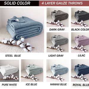 May include: A collection of 4-layer gauze throws in various solid colours, including steel blue, dark grey, light grey, lilac, pure white, ice blue, hawaii blue, and royal blue. The throws are folded and displayed on a white surface.