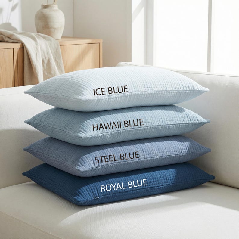 Pode incluir: Quatro almofadas azuis empilhadas em um sof&aacute; branco. A almofada superior &eacute; azul gelo, seguida por azul Hava&iacute;, azul a&ccedil;o e azul royal. Cada almofada tem uma superf&iacute;cie texturizada e o nome da cor impresso.