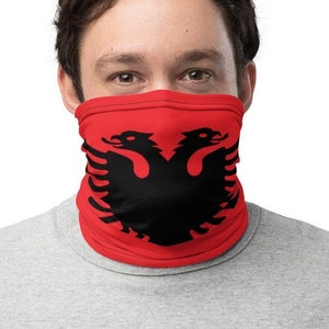 May include: A red face mask with a black double-headed eagle design. The eagle is the national symbol of Albania.