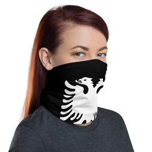 May include: A black face mask with a white Albanian eagle design. The mask is made of a soft, breathable fabric and is designed to be comfortable to wear.