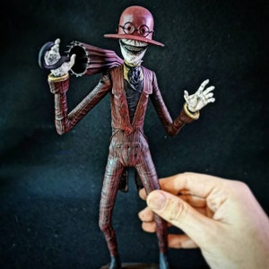 May include: A red and black striped suit with a red top hat and glasses. The figure has a wide smile and is holding an umbrella.