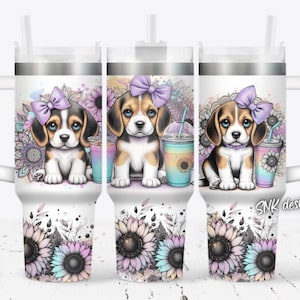 May include: Three stainless steel tumblers with a white background and a design of a beagle puppy wearing a purple bow. The design also includes sunflowers and mandala patterns. The tumblers have a silver lid and a straw.