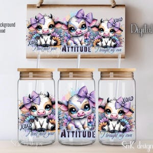 May include: Three clear glass tumblers with bamboo lids and straws. Each tumbler features a different cartoon cow with a purple bow and flowers. The text on the tumblers reads "I don't need your attitude", "I brought my own attitude", and "XOXO I brought my own".