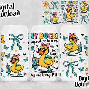 Op de afbeelding: Drie witte drankblikjes met een cartoon eendenontwerp. De eenden dragen een zonnebril en rolschaatsen en houden drankjes vast. Het ontwerp bevat de tekst "MY DUCKS may not be in a row But at Least They are having FUN". Het ontwerp bevat ook strikken, vlinders en bloemen.