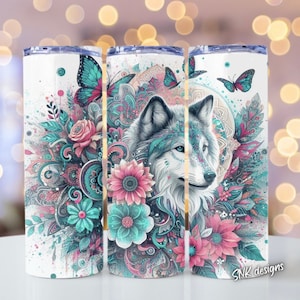Puede incluir: Un vaso de acero inoxidable blanco con un diseño colorido que presenta un lobo, flores y mariposas. El diseño es una mezcla de colores rosa, azul y verde. El vaso tiene un fondo blanco y el texto "SNK designs" está impreso en la parte inferior.