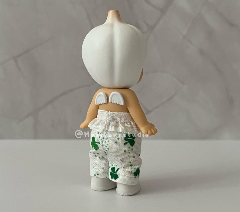 May include: A white ceramic mug with a black handle and the text "But First, Coffee" in a handwritten style. The mug is on a white surface. The mug is approximately 4 inches tall.