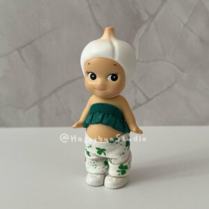 May include: A white ceramic mug with a black handle and the text "But First, Coffee" in a bold, black font. The mug is set against a blurred background, suggesting a cozy setting.