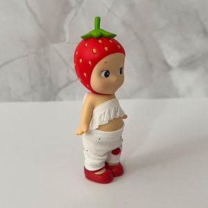 May include: A rustic wooden sign with the text "Welcome" in a handwritten style. The sign is painted white with a distressed finish, and a small, decorative heart is attached to the bottom. The background is a blurred image of a wooden surface.