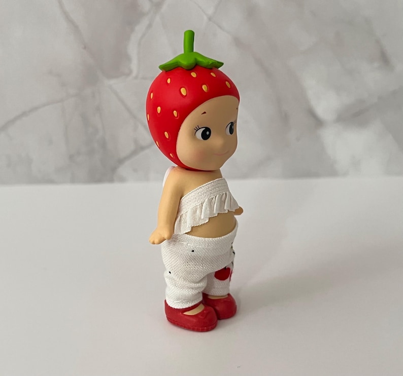 May include: A rustic wooden sign with the text "Welcome" in a handwritten style. The sign is painted white with a distressed finish, and a small, decorative heart is attached to the bottom. The background is a blurred image of a wooden surface.