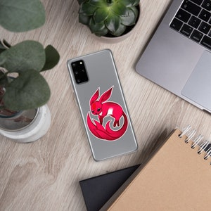 May include: A phone case with a red fox illustration. The fox is curled up with its tail wrapped around its body. The fox has a white chest and a red body.