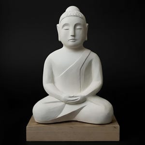 Könnte beinhalten: Eine weiße Buddha-Statue in sitzender Meditationshaltung, ruhend auf einem hellbraunen Holzsockel. Die Figur hat geschlossene Augen und einen ruhigen Ausdruck. Der Hintergrund ist einfarbig schwarz.