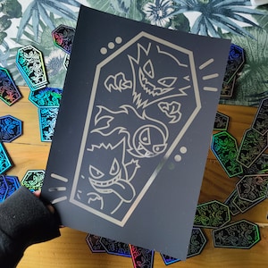 May include: Black and white illustration of three ghost-like Pokemon characters in a coffin-shaped frame. The characters are outlined in white against a black background.