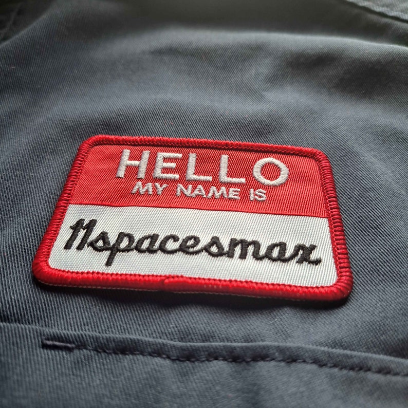 May include: Red and white name tag with the text "HELLO MY NAME IS" and the name "spacesmax" in black lettering.