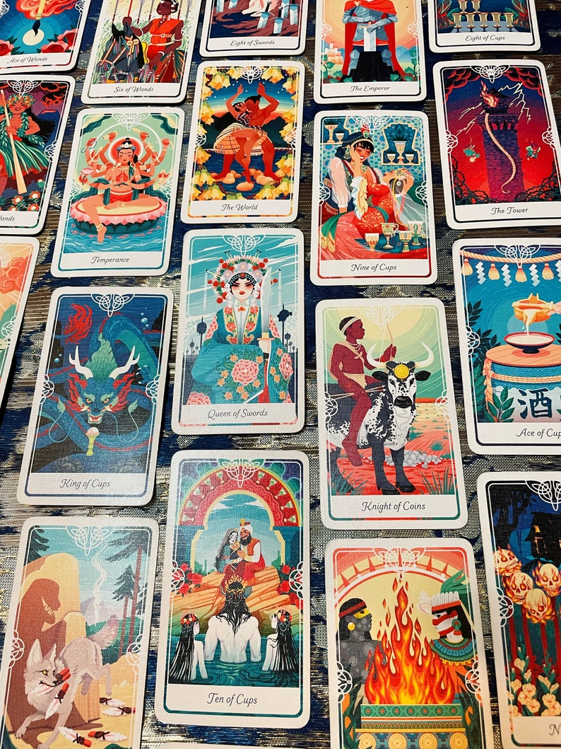 Pode incluir: Um conjunto de cartas de tar&ocirc; com ilustra&ccedil;&otilde;es coloridas que retratam v&aacute;rias cenas e personagens. As cartas apresentam uma variedade de cores, incluindo azul, verde, vermelho e dourado. As cartas est&atilde;o dispostas em um padr&atilde;o de grade em uma superf&iacute;cie com um padr&atilde;o azul e branco.