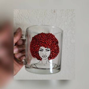 May include: A clear glass mug with a black and white illustration of a woman with a red rhinestone afro.