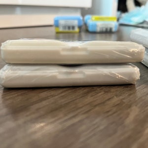 Puede incluir: Dos contenedores de pl&aacute;stico blanco apilados uno encima del otro. Los contenedores son rectangulares y tienen un acabado liso y brillante.