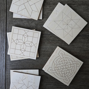 May include: Six wooden coasters with different geometric designs. The coasters are made of light wood and have a natural finish. The designs are all intricate and detailed, and they would make a great addition to any home.