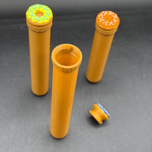 May include: Three orange-yellow cylindrical containers with donut-shaped lids. One lid is detached. The lids are decorated with yellow, orange, and blue frosting and sprinkles. The word "DIMENSION" is printed on the side of the containers.