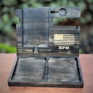 May include: A wooden valet tray with two compartments, a phone stand, and a slot for a watch. The tray is stained dark brown and has a distressed finish. The tray is personalized with the initials "EPN" and a small American flag.