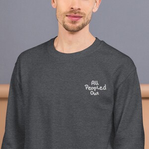Pode incluir: Uma camisa de moletom cinza escuro com o texto "ALL People Out" bordado em branco na frente.