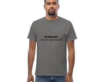 Op de afbeelding: Een grijs t-shirt met de zwarte tekst "We Belong Here. We're not going anywhere.". Het t-shirt heeft een ronde hals.