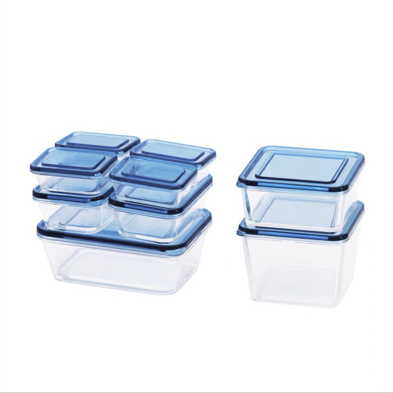 K&ouml;nnte beinhalten: Ein Satz durchsichtiger Glasbeh&auml;lter f&uuml;r Lebensmittel mit blauen Deckeln. Die Beh&auml;lter sind in zwei Gruppen gestapelt, eine mit vier Beh&auml;ltern und eine mit zwei Beh&auml;ltern.