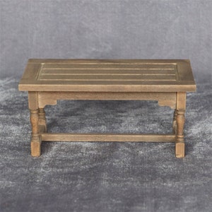 Op de afbeelding: Een rustieke houten tafel met een rechthoekig blad en vier poten. De tafel heeft een verweerde bruine afwerking en een eenvoudig ontwerp.