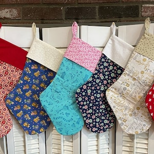 Commencez une nouvelle tradition avec ces bas de Noël 100 % coton doublés. 17 1/4" de long du poignet au bas de l'orteil. Cliquez pour voir les options de tissu.