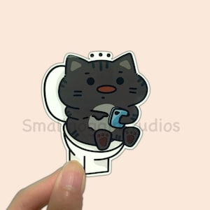 Vinylsticker Kat op het toilet - Poepmeme, grappige grijs/zwarte kat op toilet met telefoon, schattige gifsticker, vaatwasmachinebestendig, flesbestendig