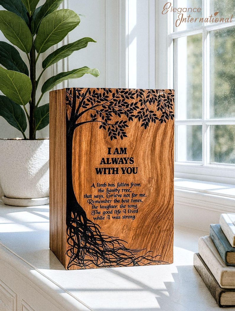 May include: A wooden box with a tree design and the words "I AM ALWAYS WITH YOU" engraved on the front. The box has a natural wood grain finish and includes a poem. The box is sitting on a white surface.